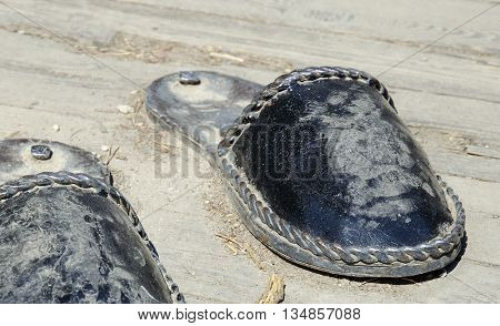 Irkutsk region Russia - May10 2015: Iron sculpture home slippers for men on wooden floor
