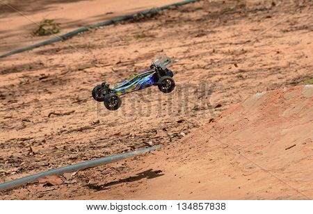 Sydney, Australia - November 30, 2014. Radio controlled buggy car model in race, internal combustion engine on a bumpy red clay road. (St Ives Showground, Sydney, Australia)