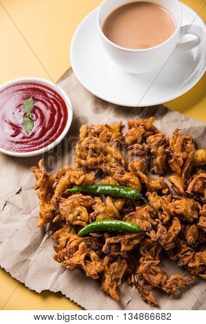 Crispy onion bhaji or kanda bhaji or fried onion pakore or pakode, delicious street food, favourite indian snack in monsoon served with hot tea