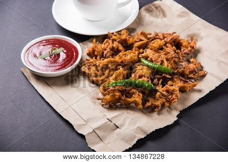 Crispy onion bhaji or kanda bhaji or fried onion pakore or pakode, delicious street food, favourite indian snack in monsoon served with hot tea