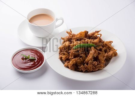 Crispy onion bhaji or kanda bhaji or fried onion pakore or pakode, delicious street food, favourite indian snack in monsoon served with hot tea