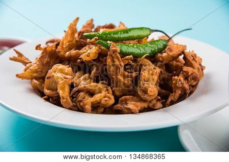 Crispy onion bhaji or kanda bhaji or fried onion pakore or pakode, delicious street food, favourite indian snack in monsoon served with hot tea