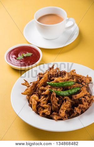 Crispy onion bhaji or kanda bhaji or fried onion pakore or pakode, delicious street food, favourite indian snack in monsoon served with hot tea