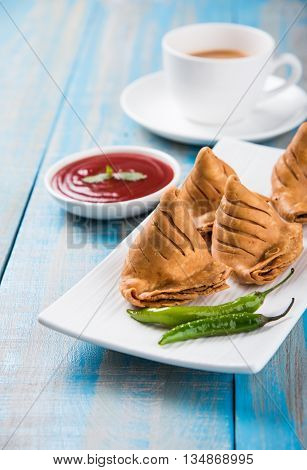 Samosa snack with tomato ketchup and hot tea, Fresh samosas with ketchup and hot chai ready for breakfast