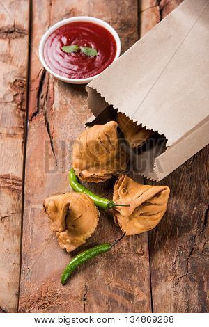 Samosa snack with tomato ketchup and hot tea, Fresh samosas with ketchup and hot chai ready for breakfast