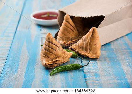 Samosa snack with tomato ketchup and hot tea, Fresh samosas with ketchup and hot chai ready for breakfast