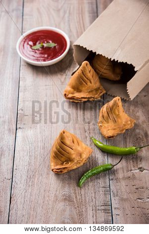 Samosa snack with tomato ketchup and hot tea, Fresh samosas with ketchup and hot chai ready for breakfast