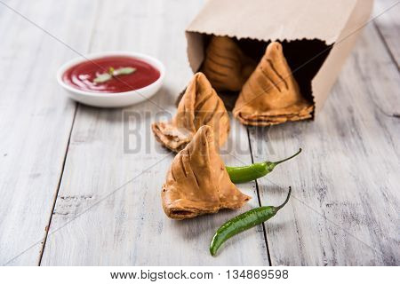 Samosa snack with tomato ketchup and hot tea, Fresh samosas with ketchup and hot chai ready for breakfast