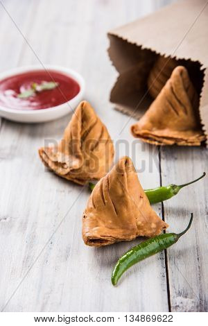 Samosa snack with tomato ketchup and hot tea, Fresh samosas with ketchup and hot chai ready for breakfast