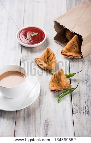 Samosa snack with tomato ketchup and hot tea, Fresh samosas with ketchup and hot chai ready for breakfast