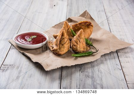 Samosa snack with tomato ketchup and hot tea, Fresh samosas with ketchup and hot chai ready for breakfast