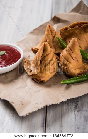 Samosa snack with tomato ketchup and hot tea, Fresh samosas with ketchup and hot chai ready for breakfast