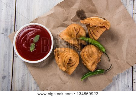 Samosa snack with tomato ketchup and hot tea, Fresh samosas with ketchup and hot chai ready for breakfast