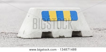 A Jersey Barrier with Retro reflector on asphalt.