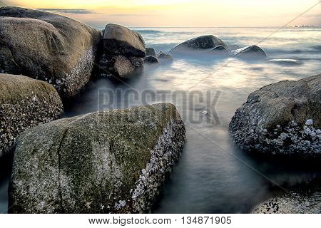 Long exposure the stone in ocean at the evening time