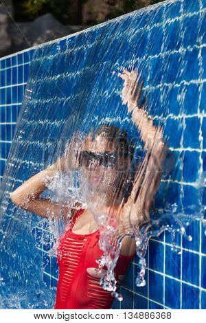 Slim woman in pool in red swimwear