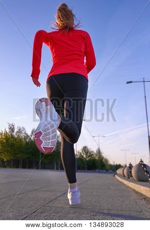 Morning jogging. Woman runinng in the park. Selective focus at the shoe.