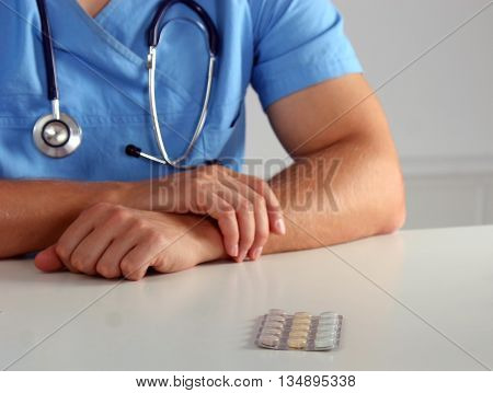 Doctor in blue uniform holding X-rays. clinic