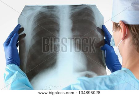 Doctor in blue uniform holding X-rays. clinic