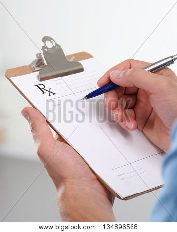 Doctor in blue uniform holding X-rays.  clinic