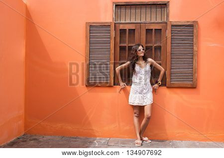 Portrait of beautiful woman standing at wooden window