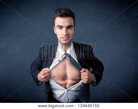 Businessman tearing off his shirt and showing mucular body concept on background