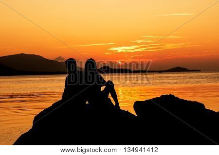 Silhouette of young couple in love at beachsunset background