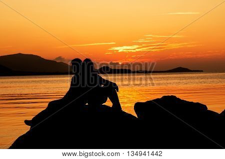 Silhouette of young couple in love at beachsunset background