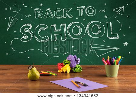 Back to school concepty with writing on blackboard and desk, apple, books, items