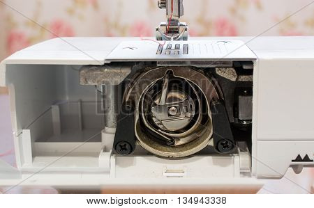Metal bobbin inside of a sewing machine