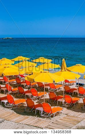 Sunbeds under a parasol on the Beach in Sarantaris village. Hersonissos. Crete, Greece.