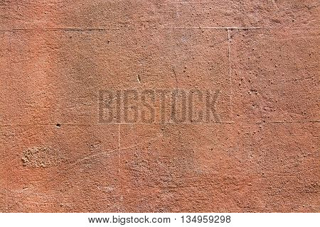 Red terra-cotta grungy roughcast horizontal background texture closeup.