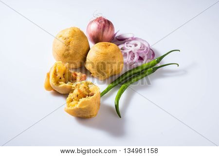 batata vada or aalu bonda or aalu bonde, a tasty indian snacks, served with tomato ketchup or green chilli and onion