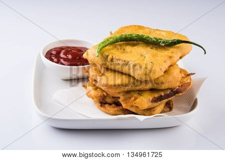 Bread Pakora or bread pakoda served along with tomato ketchup green chilly and onion slices, indian snack