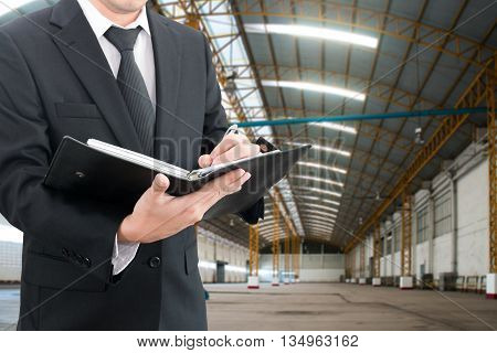Professional businessman evaluation factory with blurred construction factory building site background industrial business concept