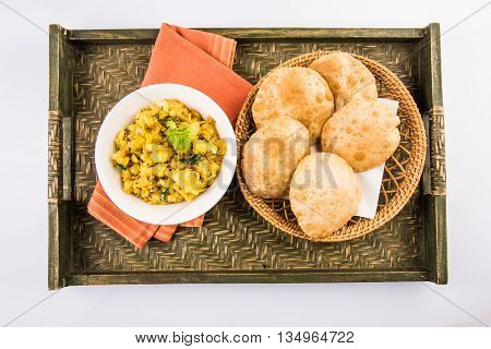 indian semi dry potato spicy recipe also known as aalu bhaji or aalu sabji served with indian puri or poori