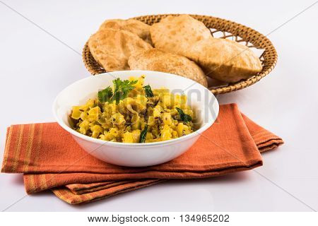 indian semi dry potato spicy recipe also known as aalu bhaji or aalu sabji served with indian puri or poori