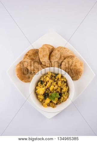 indian semi dry potato spicy recipe also known as aalu bhaji or aalu sabji served with indian puri or poori