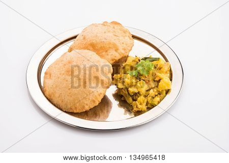 indian semi dry potato spicy recipe also known as aalu bhaji or aalu sabji served with indian puri or poori