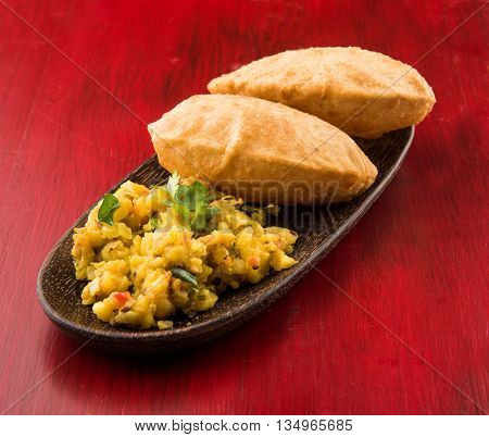 indian semi dry potato spicy recipe also known as aalu bhaji or aalu sabji served with indian puri or poori