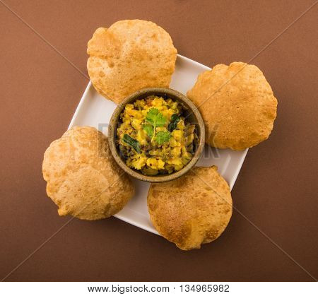 indian semi dry potato spicy recipe also known as aalu bhaji or aalu sabji served with indian puri or poori