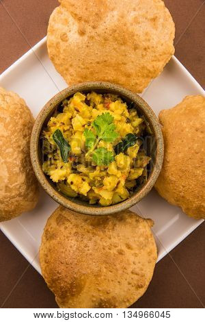 indian semi dry potato spicy recipe also known as aalu bhaji or aalu sabji served with indian puri or poori