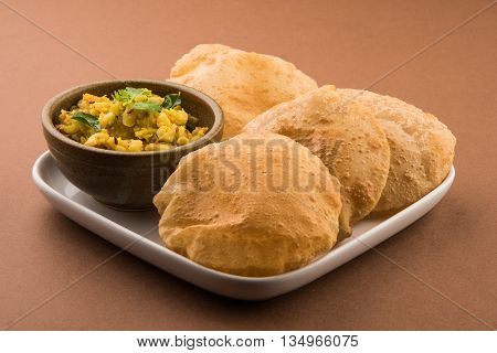 indian semi dry potato spicy recipe also known as aalu bhaji or aalu sabji served with indian puri or poori