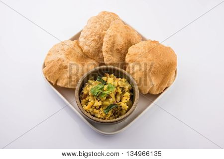 indian semi dry potato spicy recipe also known as aalu bhaji or aalu sabji served with indian puri or poori