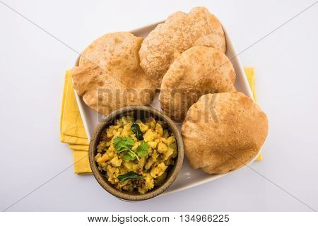 indian semi dry potato spicy recipe also known as aalu bhaji or aalu sabji served with indian puri or poori