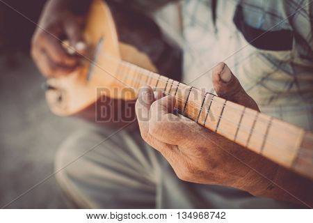 Close up shot of a man playing a Tatar instrument called 