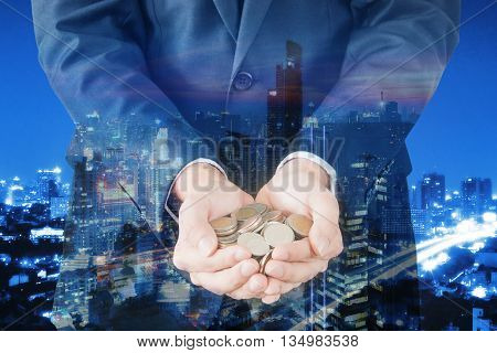 Double exposure of cityscape and businessman collect many coins on hands finance and banking concept