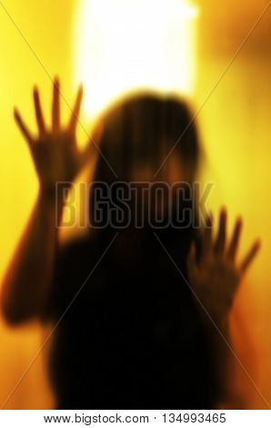 Horror woman behind the matte glass. Blurry hand and body figure abstraction.