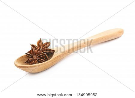 Chinese star anise seed served in a wooden spoon, composition isolated over the white background