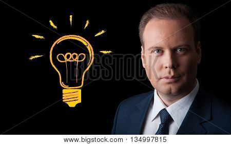 portrait of a businessman with an idea on a black background